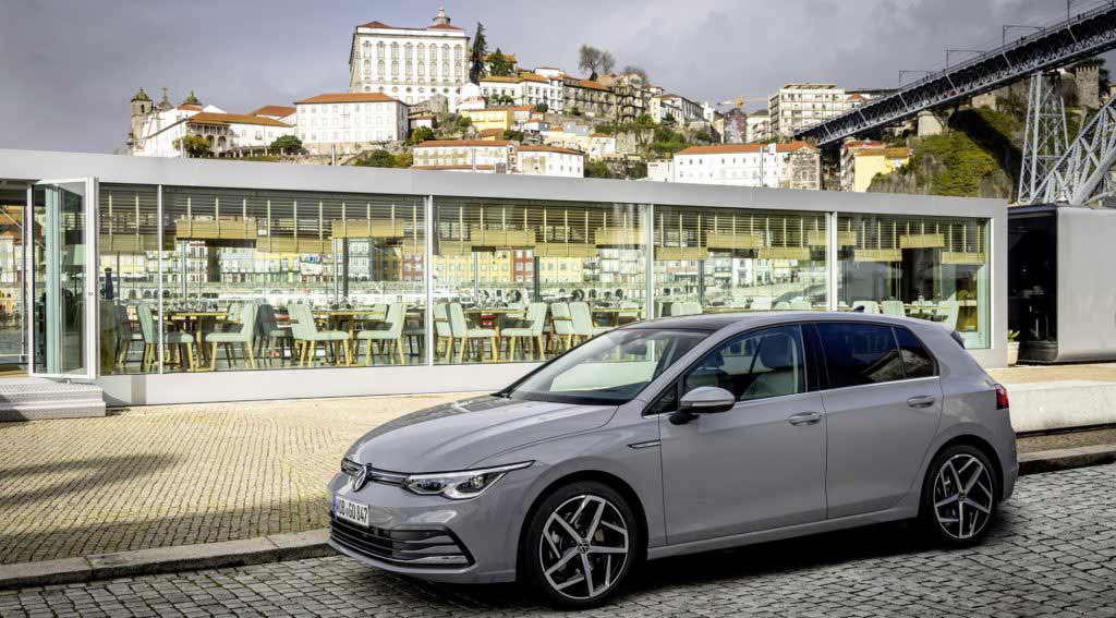 VW Golf parkt auf einer gepflasterten Straße mit einem Restaurant im Hintergrund