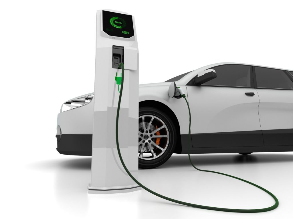 Weißes Fahrzeug mit Elektro Tanksäule im Vordergrund